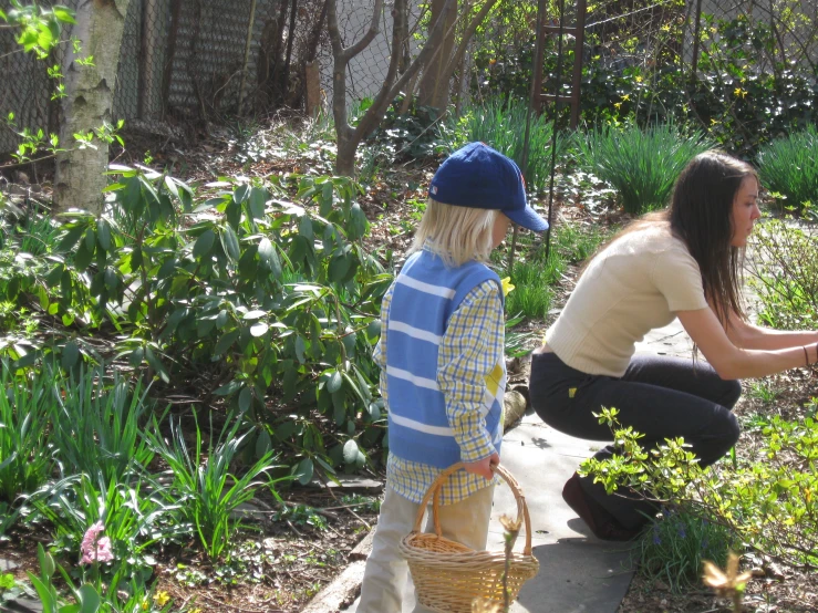 two women, who are sitting down with baskets on their laps, looking at a garden