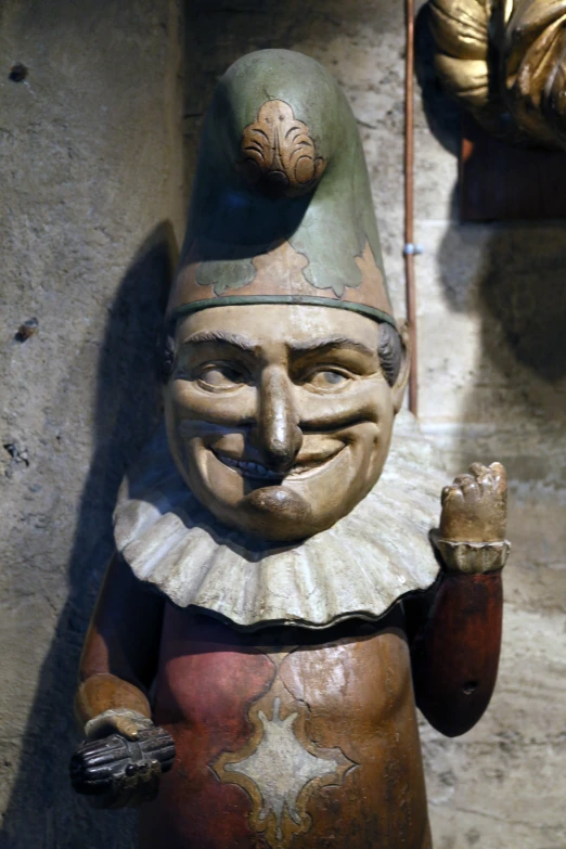 a statue of a smiling man with a hat and gloves