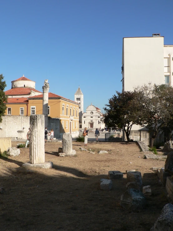 a church sitting next to a large building in a field