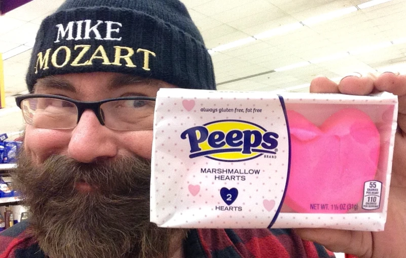 this is a man in a store with a fake heart shaped piece of cake