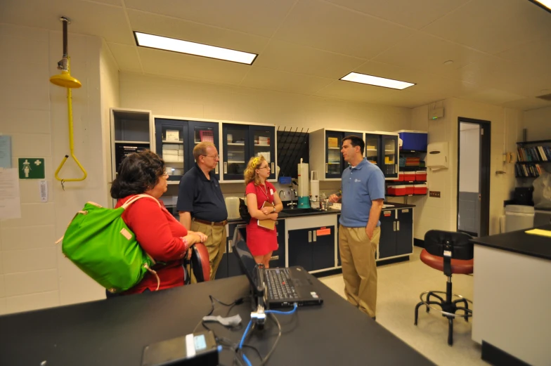 two men and a woman standing in a lab