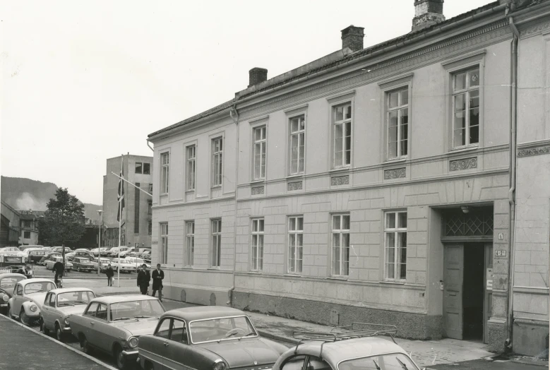 many cars are parked on the street next to some building