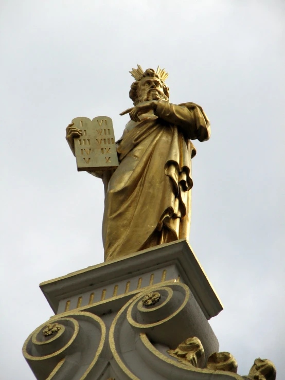 the statue is holding a book with his hand