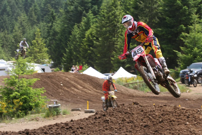 a rider is in mid air while doing tricks on a motorcycle