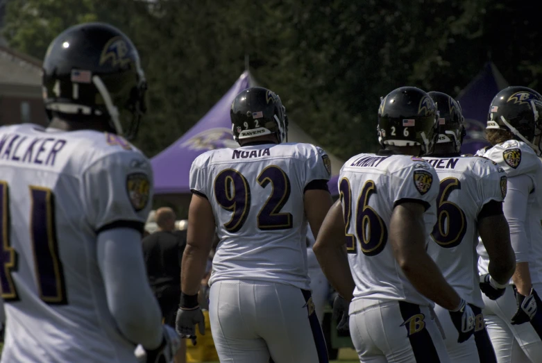 four football players in uniforms are standing on the field