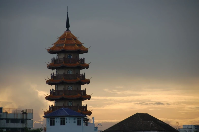 the clock tower on top of the pagoda towers against the sky