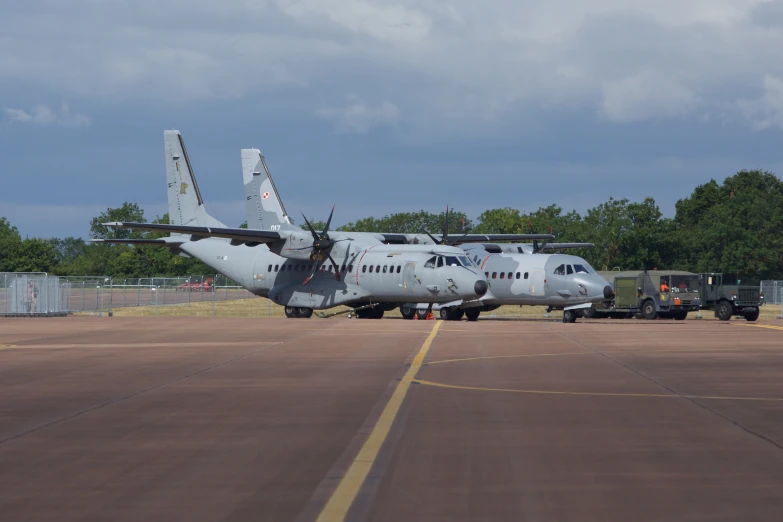 military vehicles are parked on the runway in a field