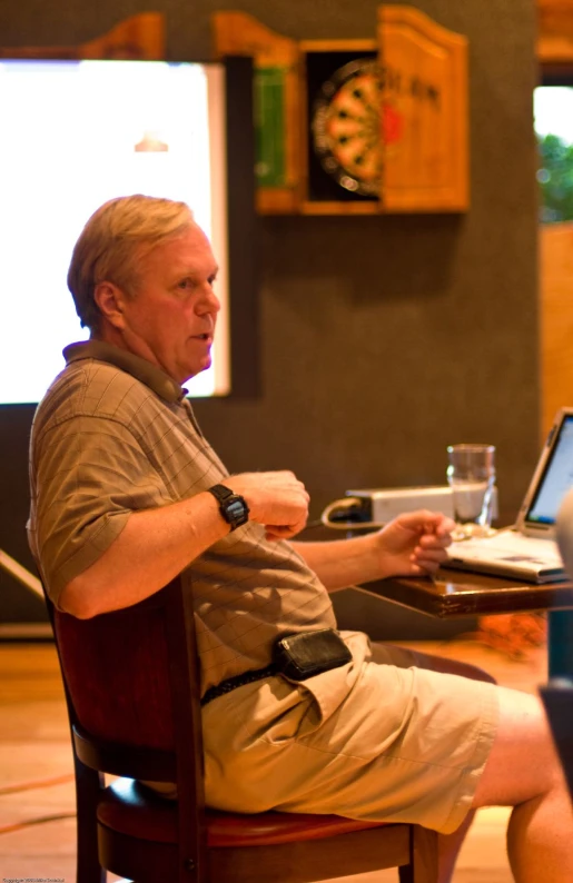 man sitting at the table typing on a laptop