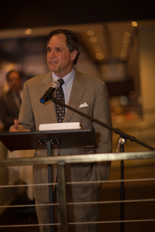 a man in suit speaking into a microphone