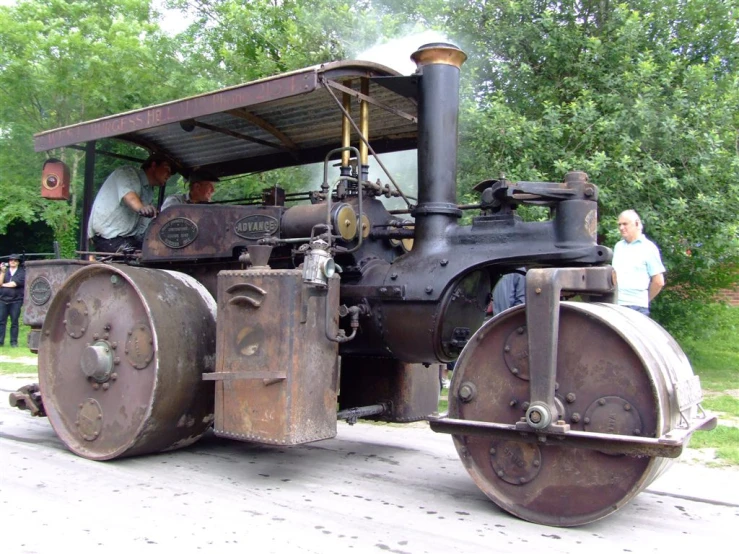 people standing around looking at an old steam engine