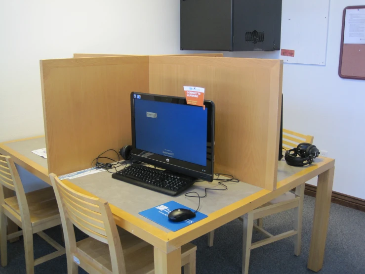 a table with a laptop on it and a monitor and keyboard