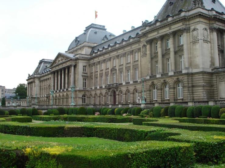 a very old building with large hedges in the front