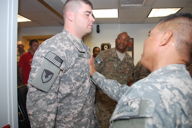 several soldiers standing around and shaking hands