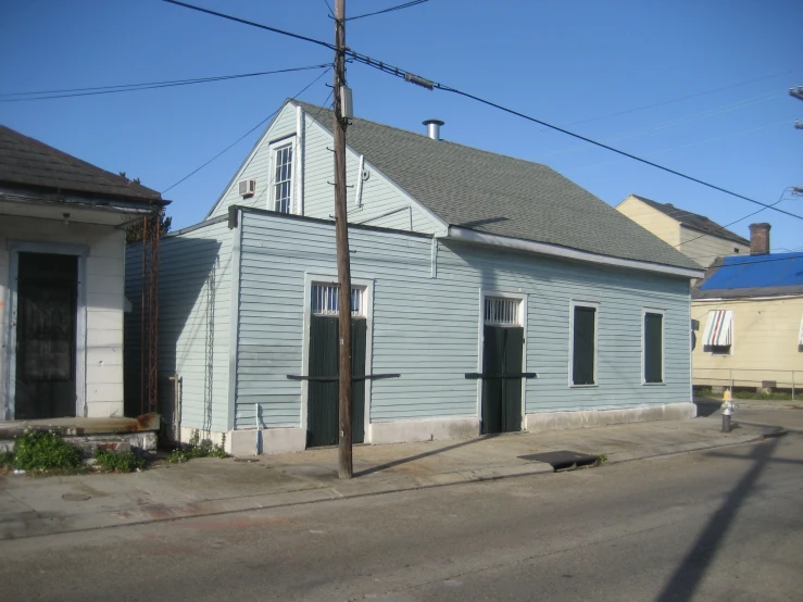 old wooden house near a street corner with power lines