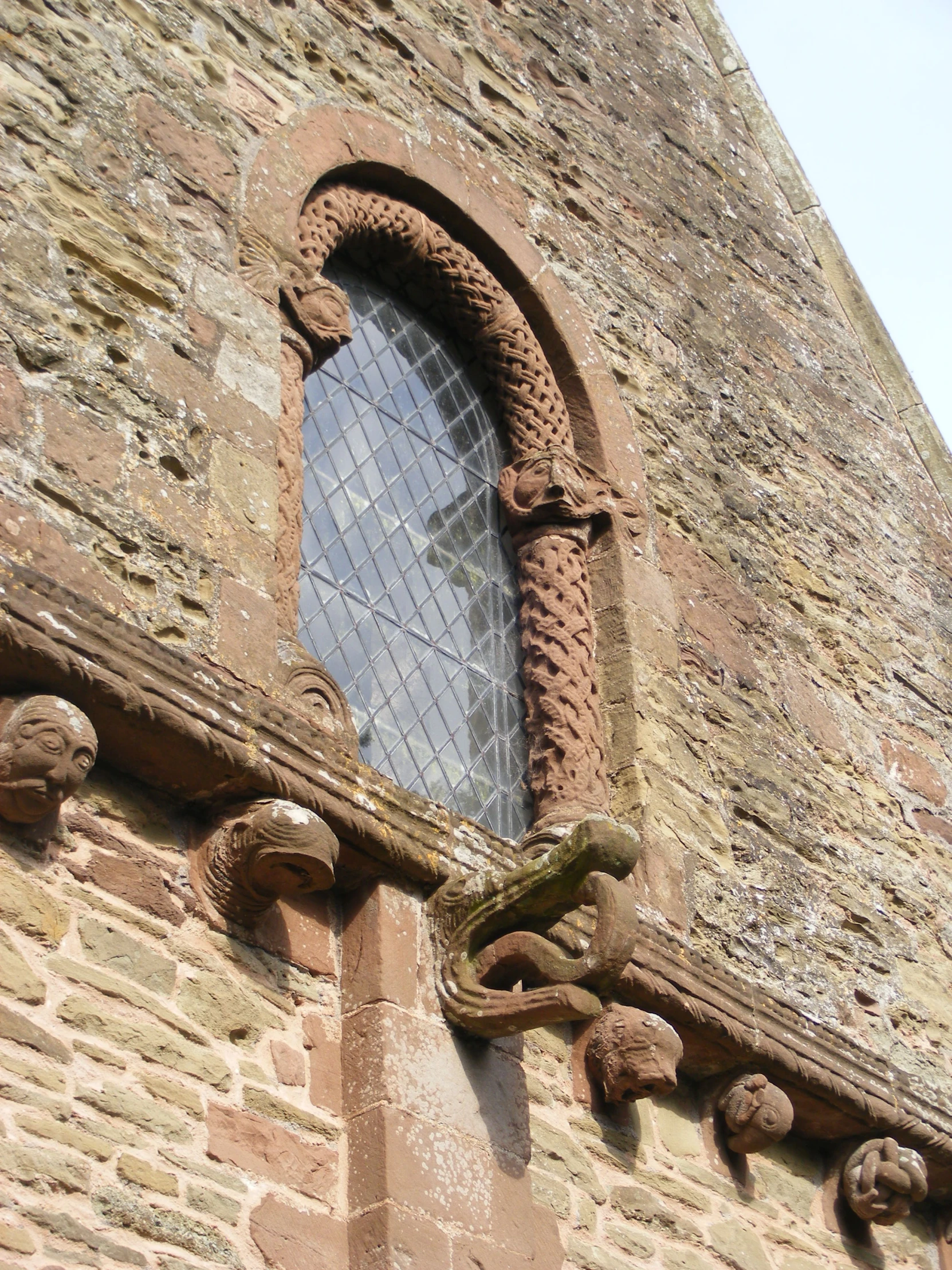 an antique brick building with arched window, decorative iron work