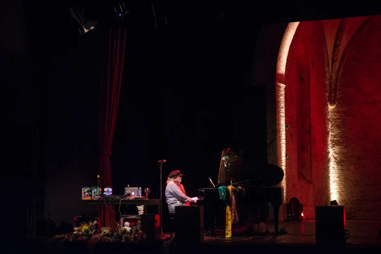 a woman on a stage playing on a piano