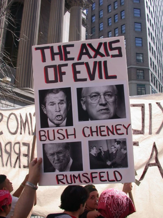 several people holding signs with political pictures on them