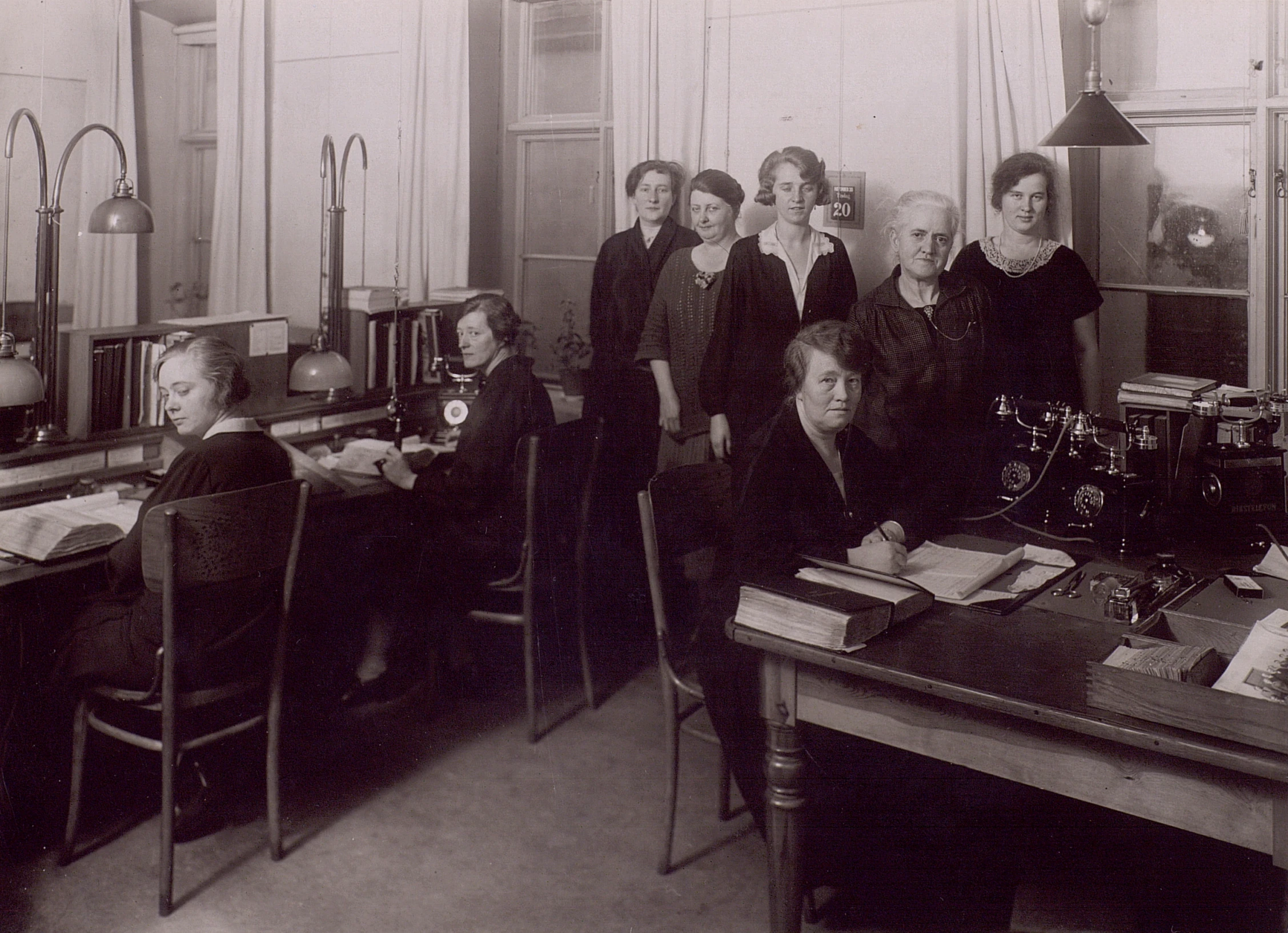 women sitting at desks and writing at the same time