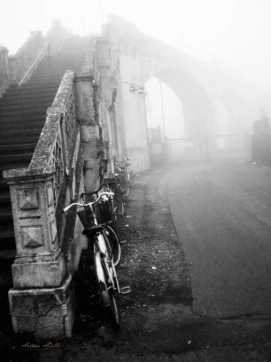 bike parked against a stone wall with stairs