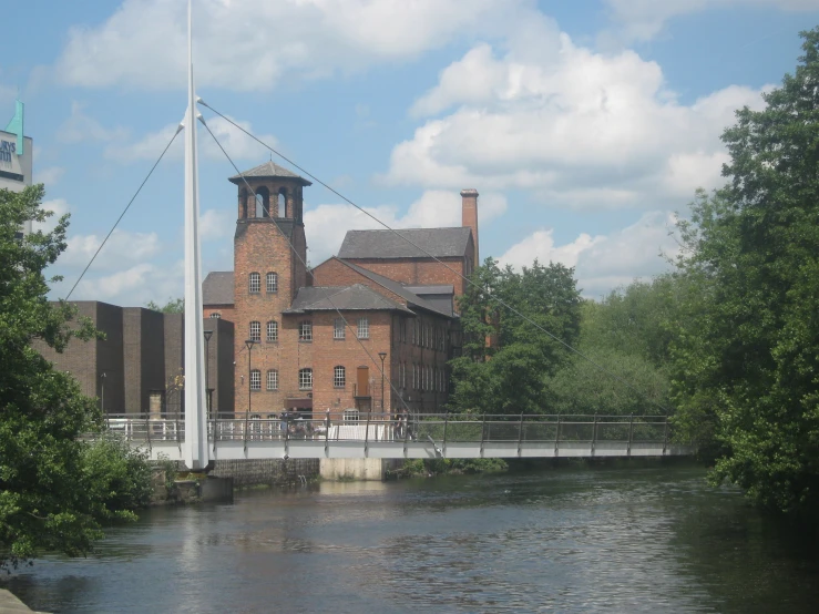 an old brick building stands beside a river