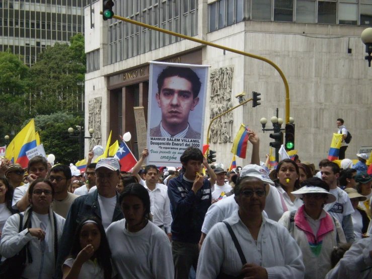 a crowd in mexico walking under a traffic light