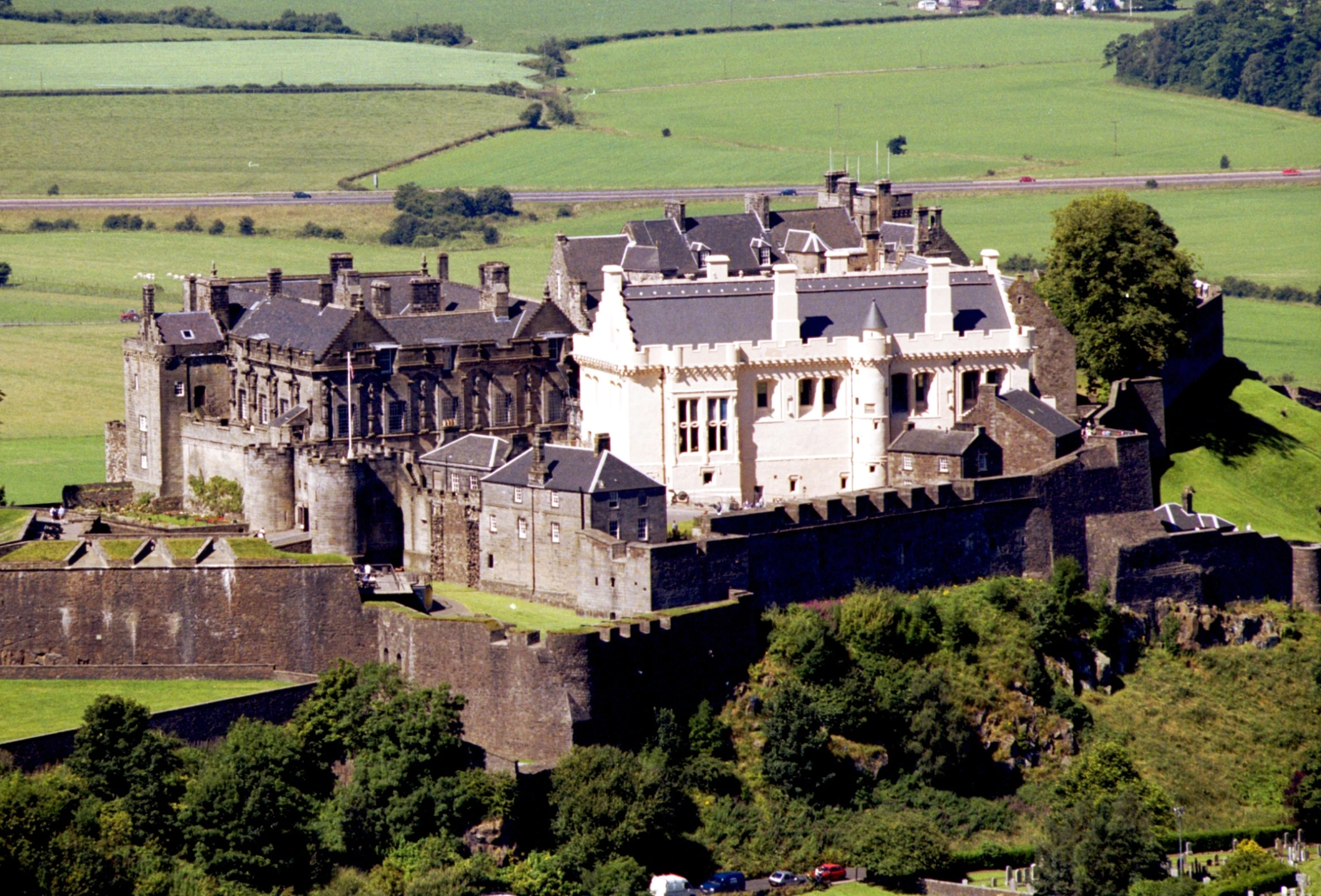 an aerial po of a castle that is very large and high on a hill