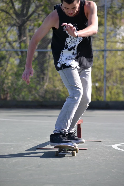 a man riding a skateboard on top of a tennis court