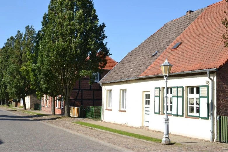 old brick houses with green trim next to a street