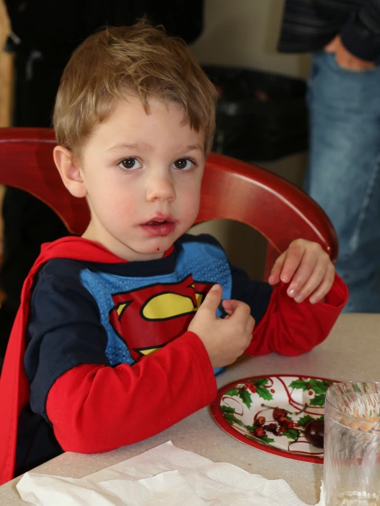 a  sitting at a table with a plate