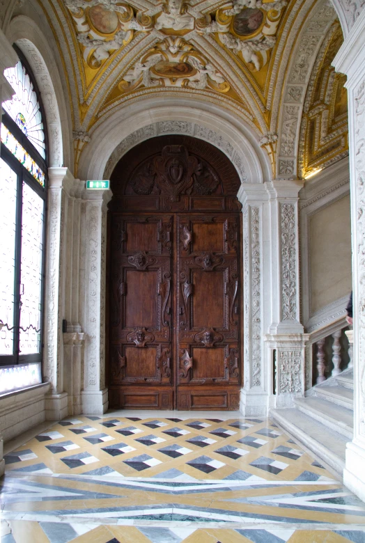 an entry hall with two large wooden doors