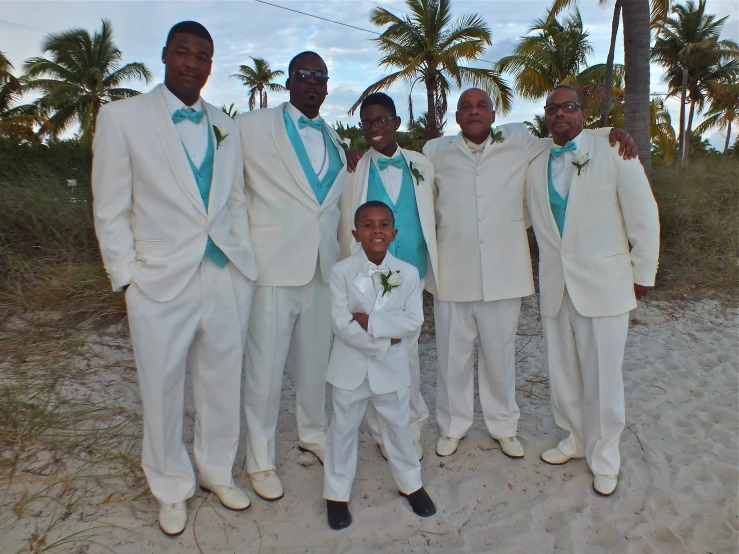 a group of men wearing white suits on top of sand
