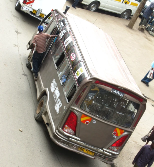 the back end of a parked car with a man standing at the side