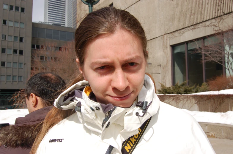 a woman in a white jacket looks intently