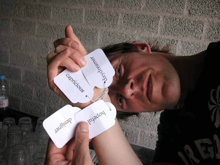a man poses with two handmade card messages