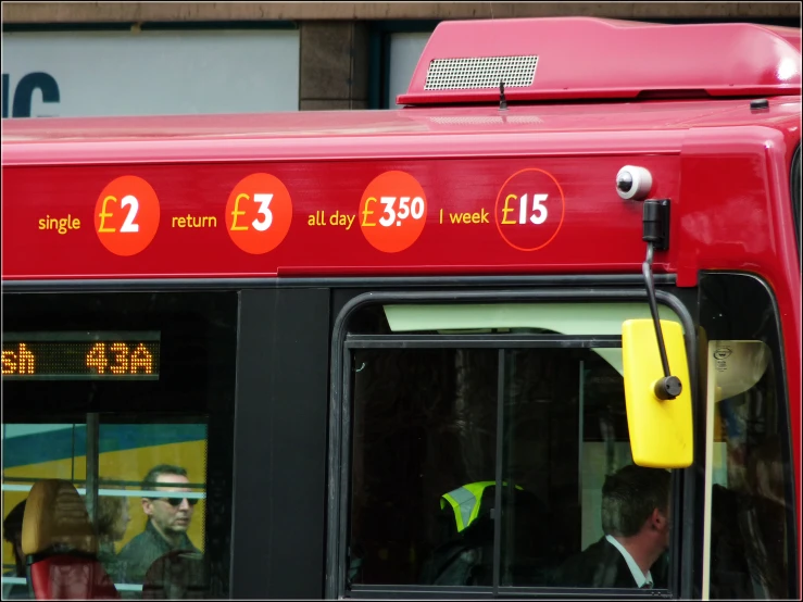 a red bus with large numbers sitting in the station