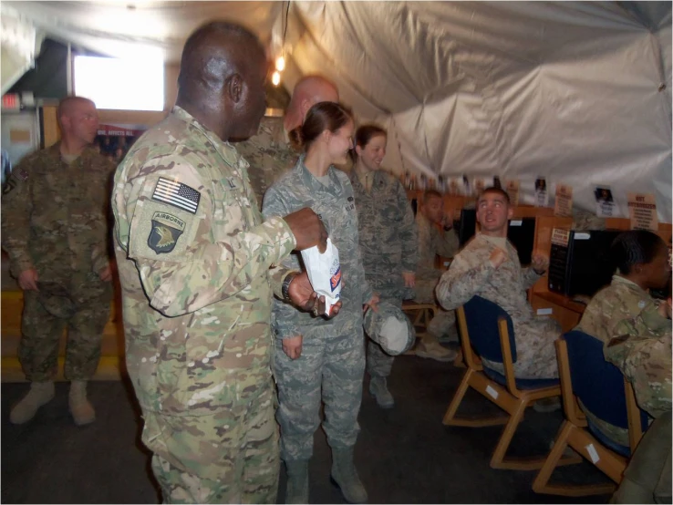 a group of soldiers standing in a tent next to each other