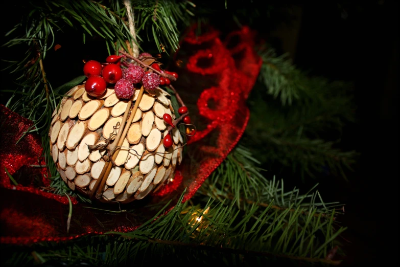 a decorative pine cone decoration hangs from a christmas tree