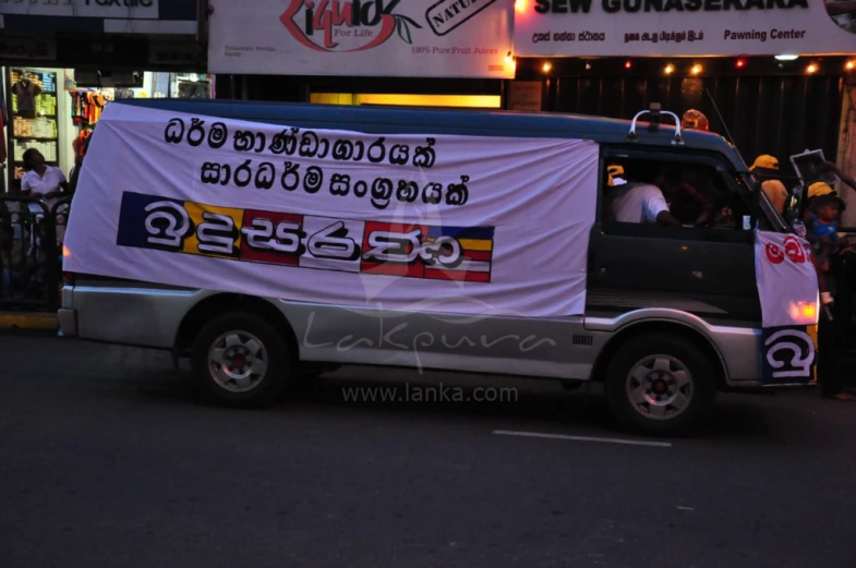 a truck on a street with a billboard covering it