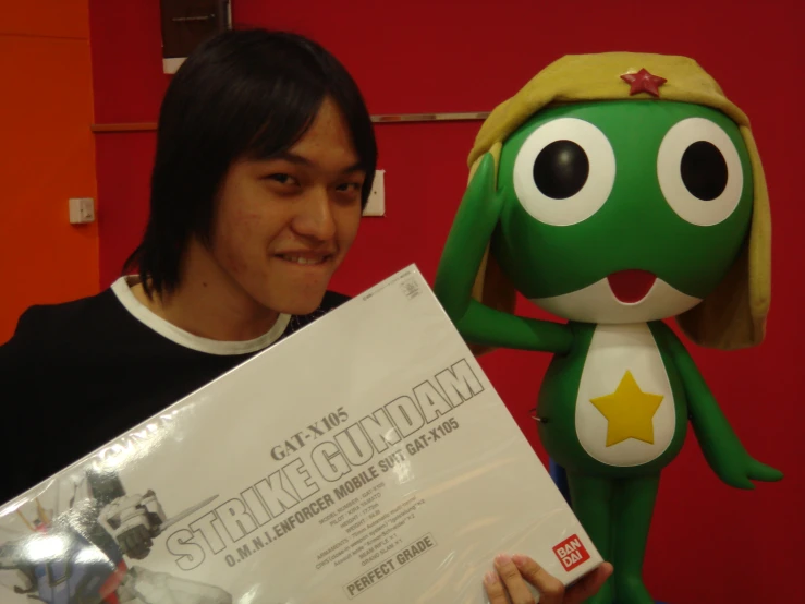 a guy holding up a giant stuffed animal and a big white sign