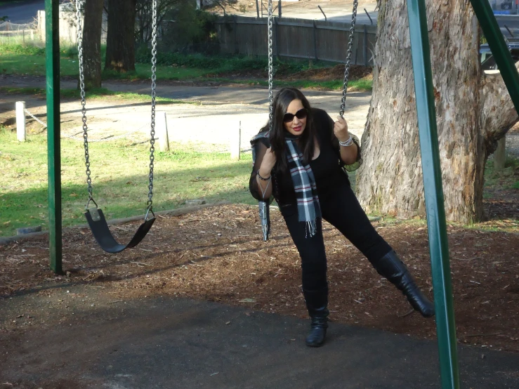 woman posing for a pograph on a swing set