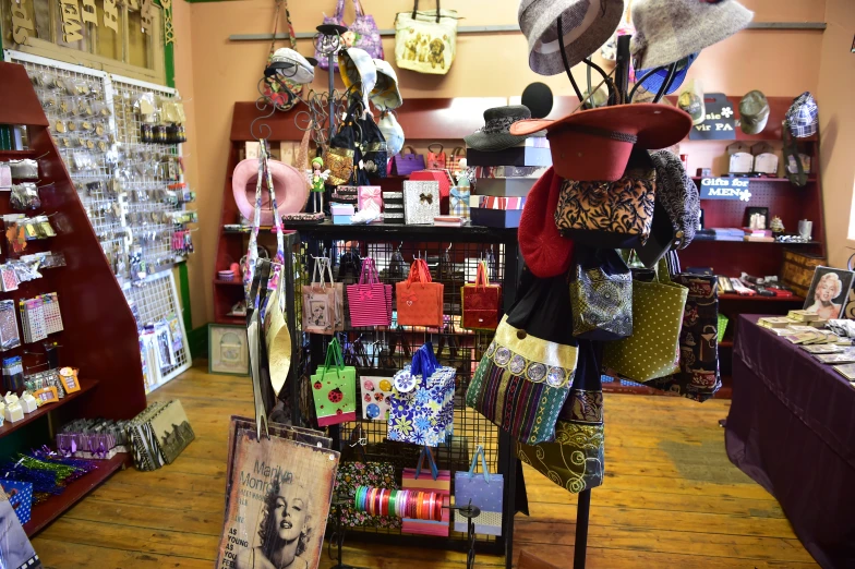 some hats and scarves are hanging from a stand in a store