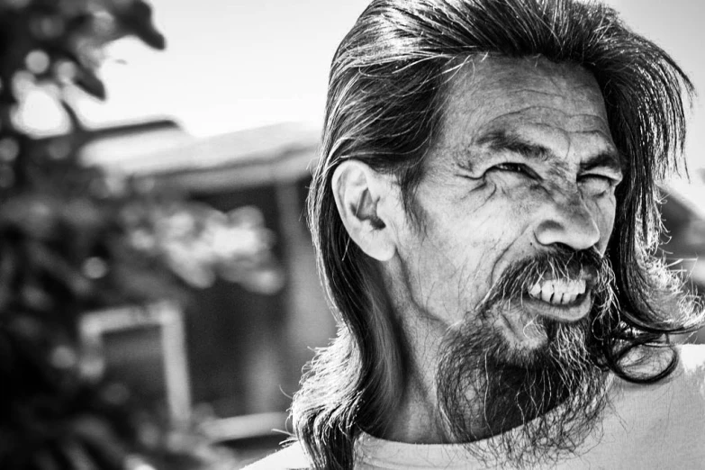 an older asian man has long hair and a goatee