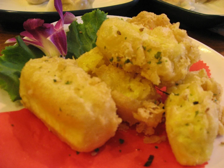 a plate with some deep fried items with a side of greens