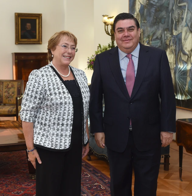 a man in a suit and tie standing next to a woman in a black dress