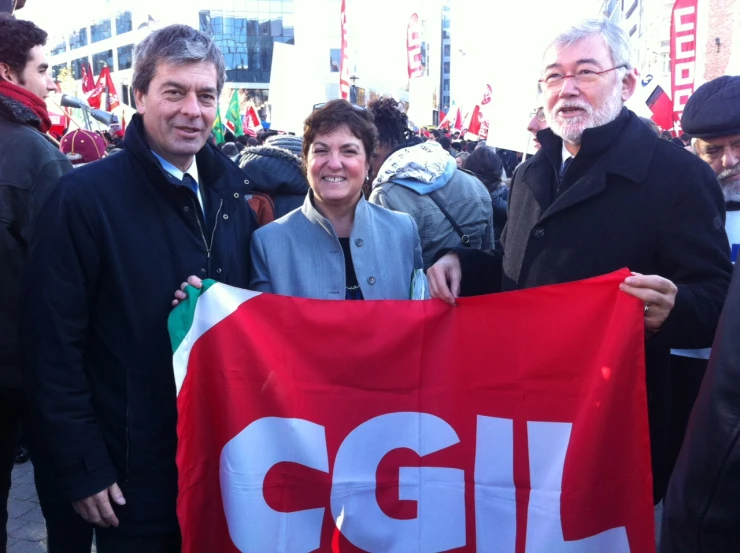 a man and woman holding up a sign in the street