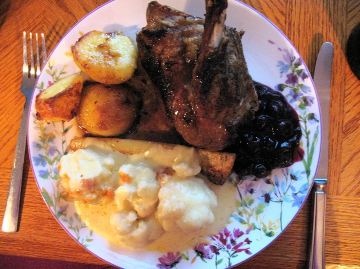 a white plate topped with meat and potatoes
