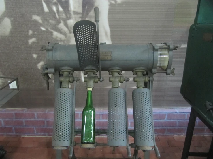 a bottle is sitting in a machine on a brick surface