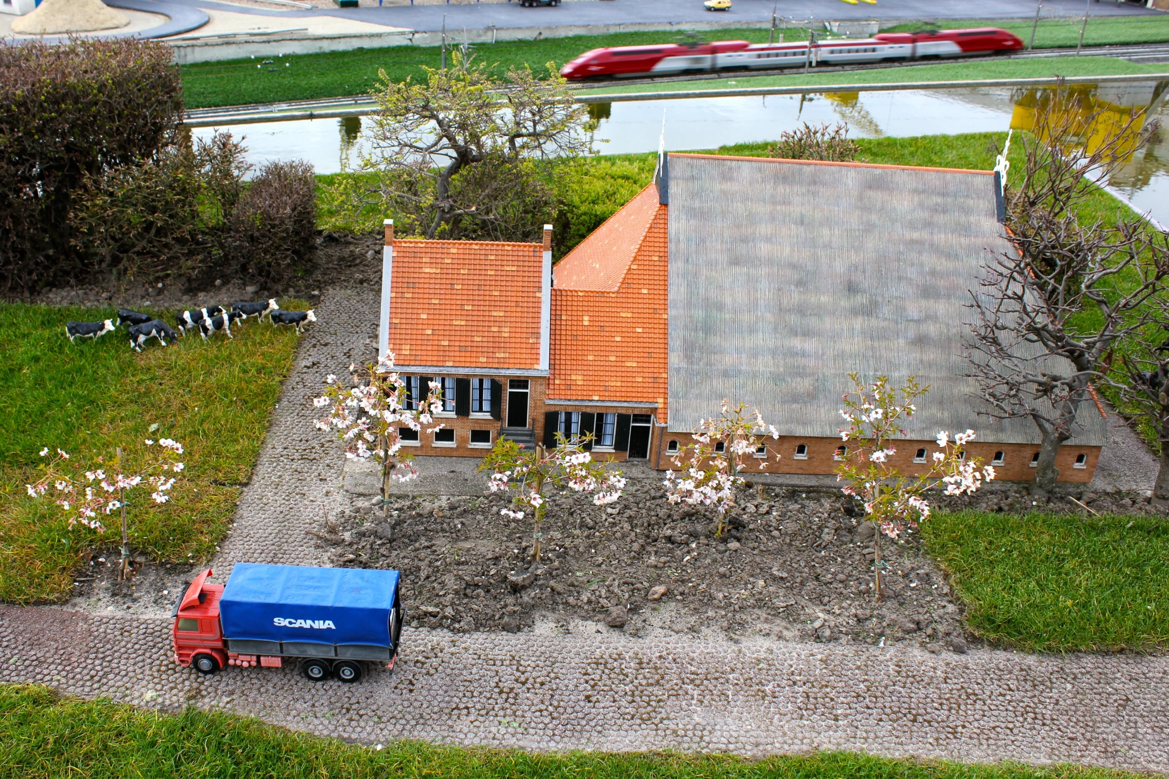 a blue truck parked in front of a model house