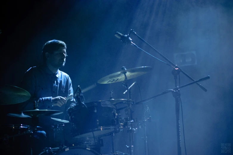 a man with drums playing on stage