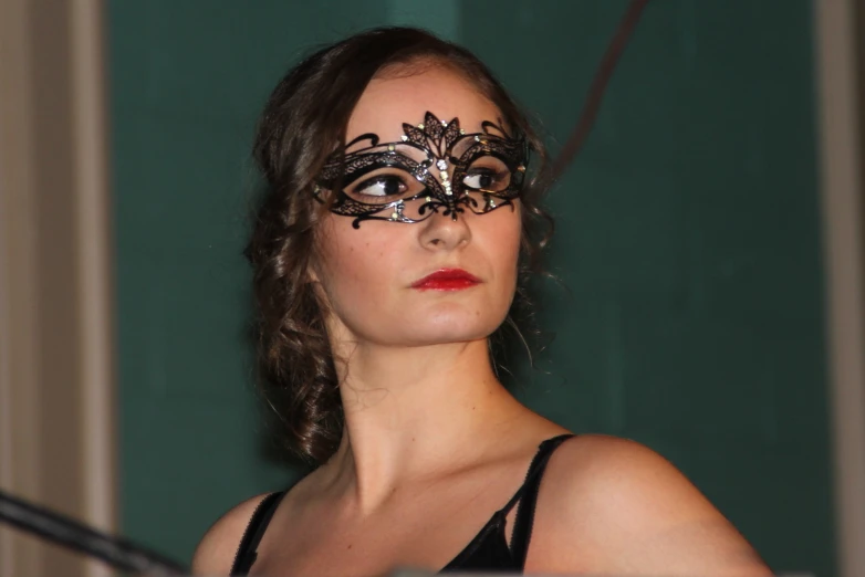 a woman with a black masquerade is staring at soing